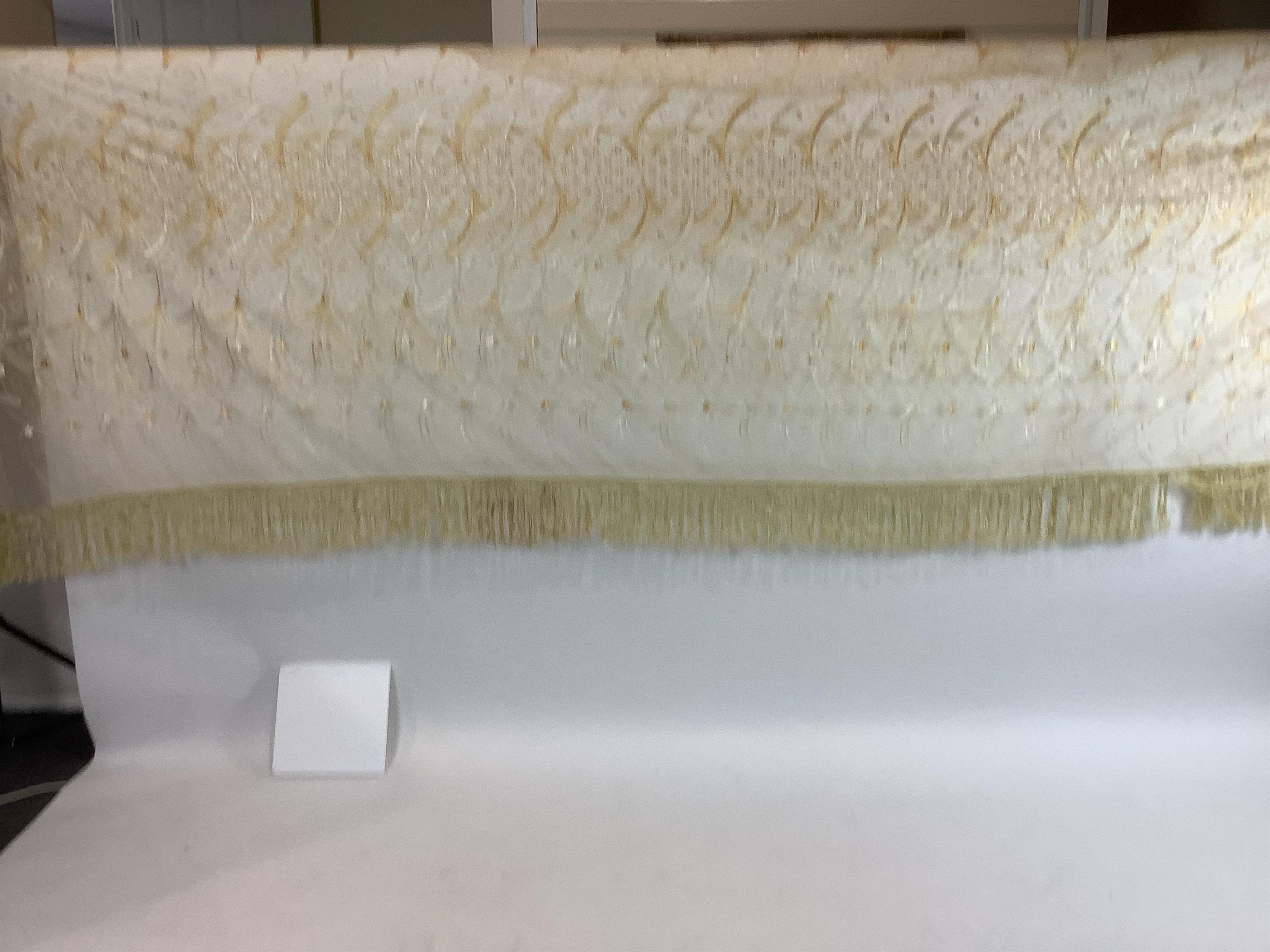 A French Art Deco wide silk yellow and cream embroidered net curtain, bordered at the bottom with yellow silk fringing. Approximately 560cm wide x 170cm long (not including fringing)., Condition - the curtain may need re